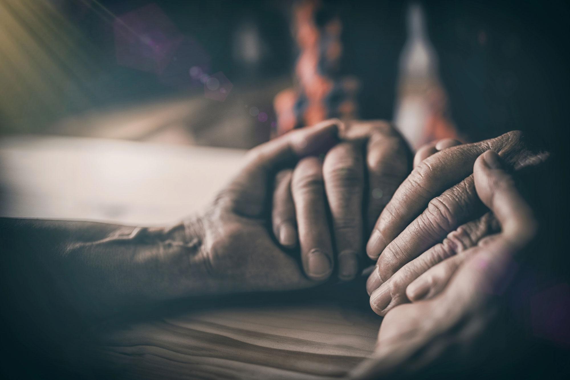 Family holding hands for support during an unattended death cleanup in Dallas